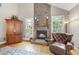 A stone fireplace anchors the living room, flanked by bright windows and classic furnishings at 204 Brittany Pl, Cary, NC 27511