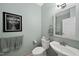 Charming powder room featuring elegant fixtures, decorative mirror, and artwork at 204 Brittany Pl, Cary, NC 27511
