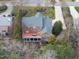An aerial view of a stunning brick home featuring a spacious deck, and lush landscaping at 204 Brittany Pl, Cary, NC 27511