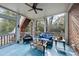Inviting screened porch with comfortable seating, ceiling fan, and views of the surrounding nature at 204 Brittany Pl, Cary, NC 27511