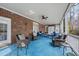 Large screened porch featuring a brick wall, ceiling fans, and blue outdoor seating at 204 Brittany Pl, Cary, NC 27511