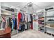 Bright walk-in closet with built-in shelving, hanging racks, drawers and a decorative chandelier at 204 Brittany Pl, Cary, NC 27511