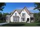 Stunning exterior elevation of a new construction house with a grey roof, light stone, and large windows at 211 Meadow Walk Dr, Fuquay Varina, NC 27526