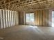 Unfinished room with framed walls and a large window offering natural light and backyard views at 211 Meadow Walk Dr, Fuquay Varina, NC 27526