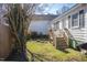 The backyard showcases a wooden staircase leading to the home, with a gas grill and trees nearby at 2606 W Knox St, Durham, NC 27705
