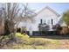View of the backyard, siding of the house, and gas grill with mature landscaping on a sunny day at 2606 W Knox St, Durham, NC 27705