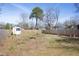 Large, fenced backyard featuring a storage shed and mature trees offering ample space for outdoor activities at 2606 W Knox St, Durham, NC 27705