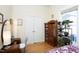Cozy bedroom featuring a wardrobe, antique cabinet, and sunny window filled with plants at 2606 W Knox St, Durham, NC 27705