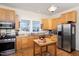 Well-lit kitchen with stainless steel appliances, light wood cabinets, and a view of the outdoors at 2606 W Knox St, Durham, NC 27705