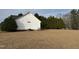 View of the home's side and backyard, showcasing its expansive lawn and mature trees at 305 River Birch Run, Coats, NC 27521