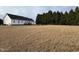 View of the house and the spacious back yard with many trees at 305 River Birch Run, Coats, NC 27521