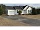 This single-story house features an attached garage and inviting front yard at 305 River Birch Run, Coats, NC 27521