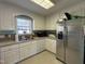Well-lit kitchen with white cabinetry, stainless steel refrigerator and updated appliances at 305 River Birch Run, Coats, NC 27521