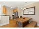 Dining area with wood table, rustic bench seating, view into the kitchen and under-cabinet lighting at 401 Finsbury St # 301, Durham, NC 27713