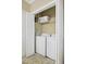 Convenient laundry closet with stacked washer and dryer, and shelving for storage at 401 Finsbury St # 301, Durham, NC 27713