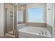 Bright bathroom featuring a garden tub and a glass enclosed shower at 456 Highview Dr, Benson, NC 27504