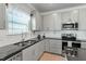 Well-lit kitchen boasts stainless appliances, sleek gray cabinets, black countertops and subway tile backsplash at 456 Highview Dr, Benson, NC 27504