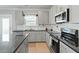 Well-equipped kitchen features gray cabinets, stainless steel appliances, and granite countertops at 456 Highview Dr, Benson, NC 27504