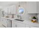 Renovated kitchen with white cabinets, quartz countertop, stainless steel sink and a round window at 4610 Lemon Heights Dr, Sanford, NC 27332