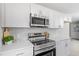 Close-up of kitchen featuring stainless steel appliances, white cabinets, and quartz countertops at 4610 Lemon Heights Dr, Sanford, NC 27332