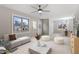 Cozy living room with neutral tones, modern furniture, a ceiling fan, and large windows for natural light at 4610 Lemon Heights Dr, Sanford, NC 27332