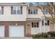 Two-story townhome with attached garage, brick facade, and light yellow vinyl siding at 4618 Pooh Corner Dr, Raleigh, NC 27616
