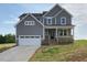 Charming two-story home featuring a stone foundation, inviting front porch, and a convenient two-car garage at 4881 Grosbeak Ct, Mebane, NC 27302