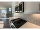 Modern kitchen featuring stainless steel appliances, a stylish backsplash, and a view of the staircase at 4881 Grosbeak Ct, Mebane, NC 27302