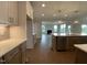 Open kitchen featuring hardwood floors, quartz countertops, stainless steel appliances, and backyard views at 4881 Grosbeak Ct, Mebane, NC 27302