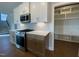 A kitchen featuring stainless steel appliances, white cabinets, hardwood floors, and built in shelving at 4881 Grosbeak Ct, Mebane, NC 27302