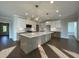 Spacious kitchen featuring a large island, stainless steel appliances, pendant lighting, and hardwood flooring at 4881 Grosbeak Ct, Mebane, NC 27302