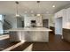 Open kitchen featuring a large island with modern pendant lighting, stainless appliances, and custom cabinetry at 4881 Grosbeak Ct, Mebane, NC 27302