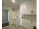 Laundry room features white cabinets, sink, and tile flooring, with a door to another room at 4881 Grosbeak Ct, Mebane, NC 27302