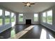 Bright living room features fireplace, ceiling fan, and hardwood floors, with large windows providing ample natural light at 4881 Grosbeak Ct, Mebane, NC 27302
