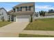 Charming two-story home with gray siding, black shutters, a two-car garage, and a well-manicured lawn at 50 Fontaine Dr, Franklinton, NC 27525