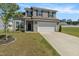 Charming two-story home with gray siding, black shutters, a two-car garage, and a well-manicured lawn at 50 Fontaine Dr, Franklinton, NC 27525