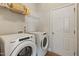 Bright laundry room features a Whirlpool washer and dryer, storage shelf, and white painted paneled door at 50 Fontaine Dr, Franklinton, NC 27525