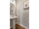 Stylish powder room featuring a pedestal sink, round mirror and fun Highland Cow art at 50 Fontaine Dr, Franklinton, NC 27525