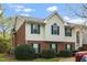 Charming townhouse with brick and siding, showcasing green shutters and manicured landscaping at 521 Renshaw Ct, Cary, NC 27518