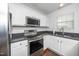 Updated kitchen showcases stainless steel appliances, dark countertops, and white cabinetry at 521 Renshaw Ct, Cary, NC 27518