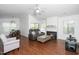 Bright living room with a fireplace, ceiling fan, wood floors, and comfortable seating at 521 Renshaw Ct, Cary, NC 27518