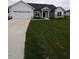 New construction home with gray and white siding, a large lawn, and a spacious driveway and two-car garage at 530 Sweet Potato Lane # 41, Nashville, NC 27856