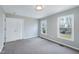 Spacious bedroom featuring neutral walls, soft carpet, and two windows at 5635 Paragon Cir, Durham, NC 27712