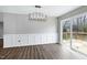 Well-lit dining room featuring modern lighting, wainscoting and a sliding door leading to a wooden deck at 5635 Paragon Cir, Durham, NC 27712