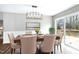 Elegant dining area featuring modern lighting, a large window with deck access, and ample seating at 5635 Paragon Cir, Durham, NC 27712