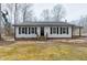 Charming ranch-style home featuring black shutters and neutral siding, complemented by a well-maintained front yard at 5635 Paragon Cir, Durham, NC 27712