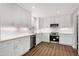 Bright kitchen featuring white cabinets, stainless steel appliances, stone countertops and wood-look flooring at 5635 Paragon Cir, Durham, NC 27712