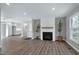 Spacious living room with a cozy fireplace, recessed lighting, and hardwood floors at 5635 Paragon Cir, Durham, NC 27712