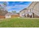 Backyard features a well-maintained lawn, wood fence, an outbuilding, and a deck with string lights and cloth at 6 Kersey Ct, Durham, NC 27713