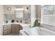 Bright bathroom with a soaking tub, large mirror, and ample natural light from the window at 6 Kersey Ct, Durham, NC 27713